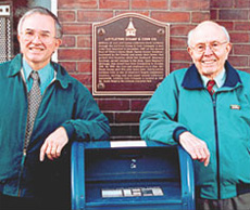 [photo: David and Maynard Sundman in front of a plaque on Littleton's Opera Block]